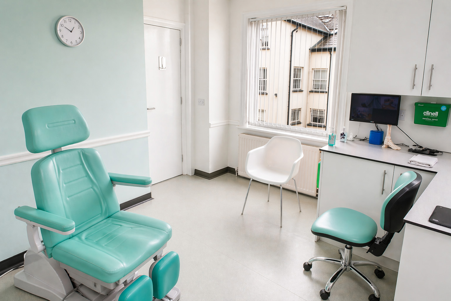 Modern podiatry treatment room with mint-teal chair at Instep Footcare